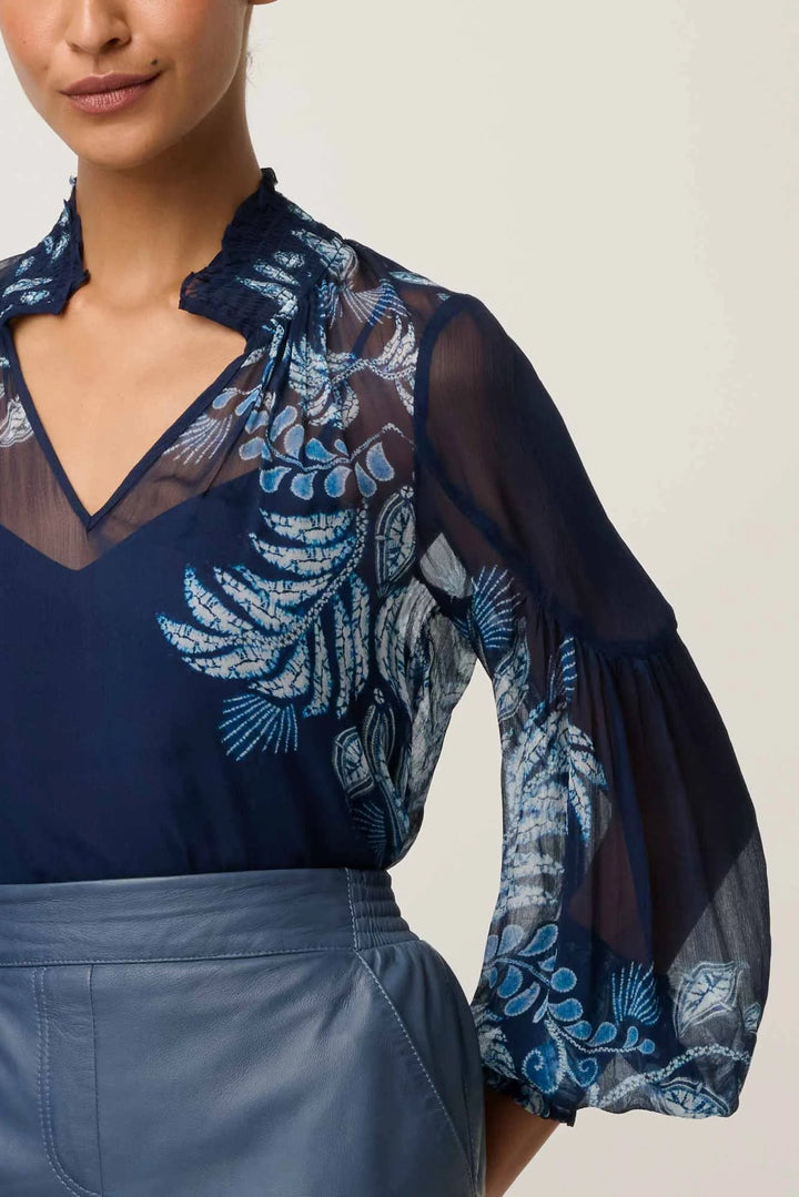 Navy blue blouse with floral embroidery on a plain background
