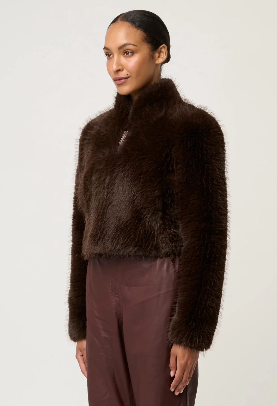 Woman wearing a brown fur jacket and pants on a white background