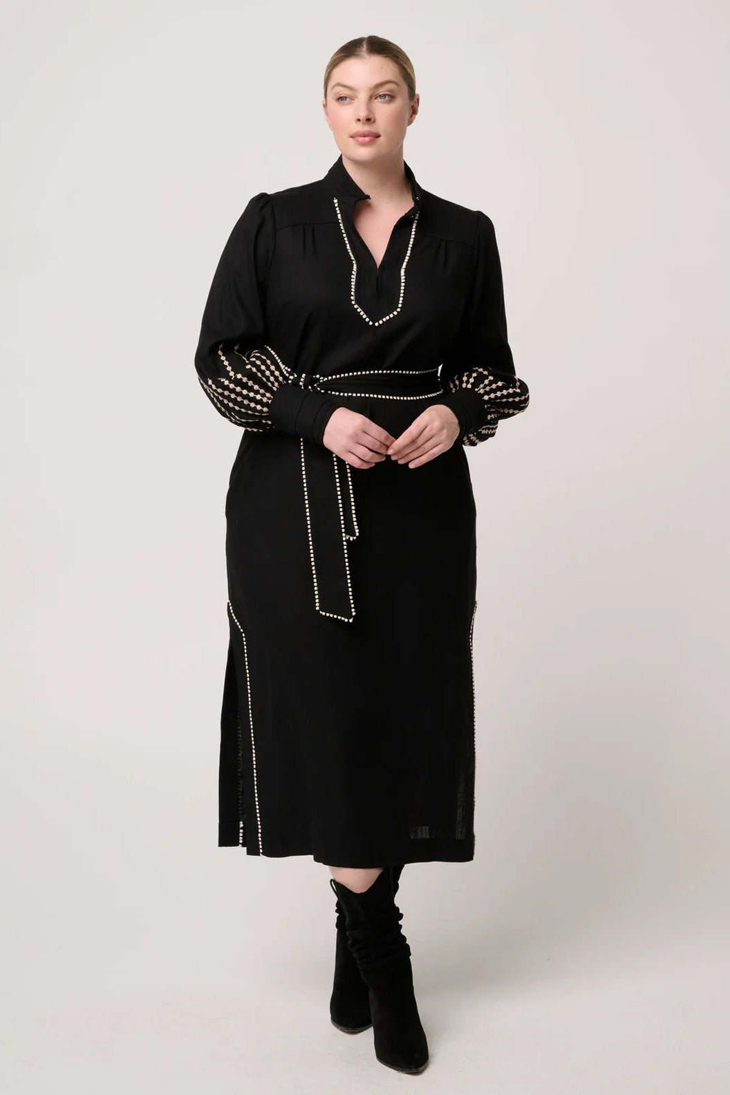 Woman wearing a black dress with decorative elements on a white background