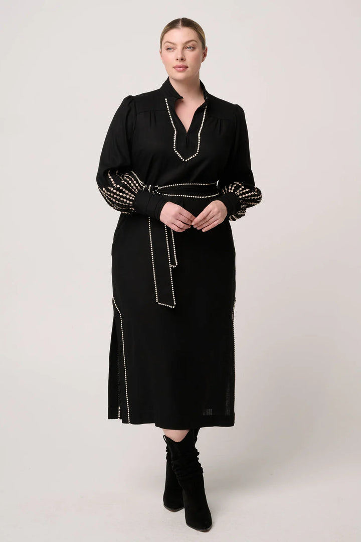 Woman wearing a black dress with decorative elements on a white background