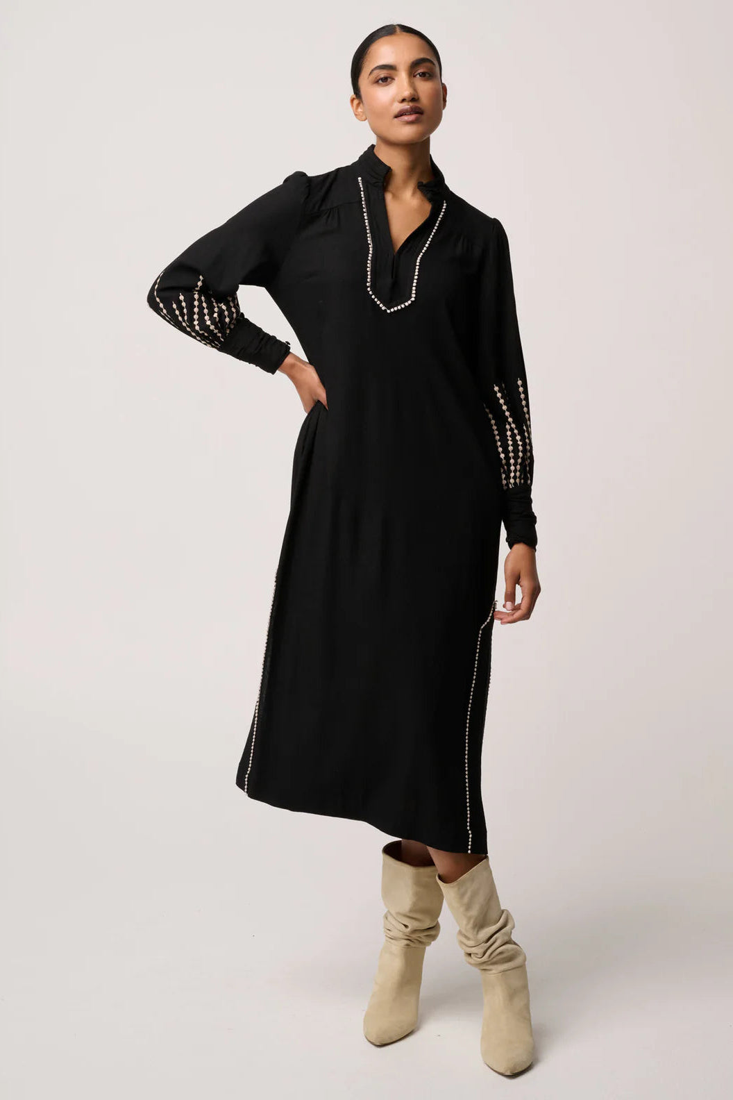 Woman wearing a black dress with white trim on a white background