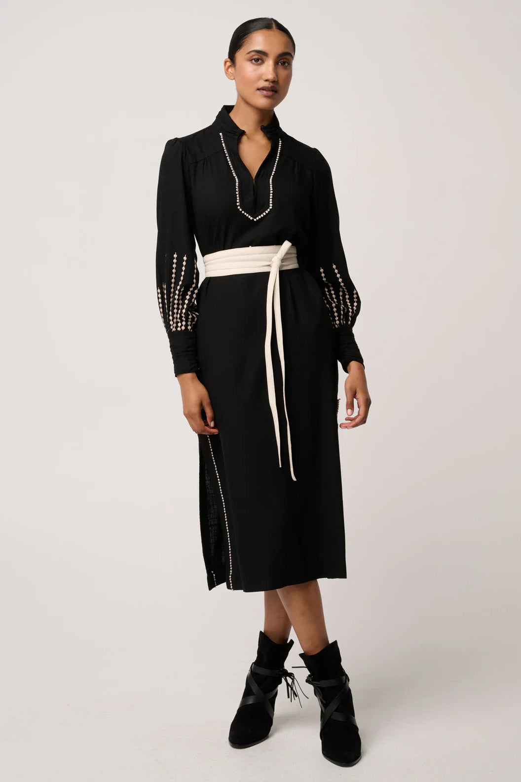Woman wearing a black dress with white trim on a white background