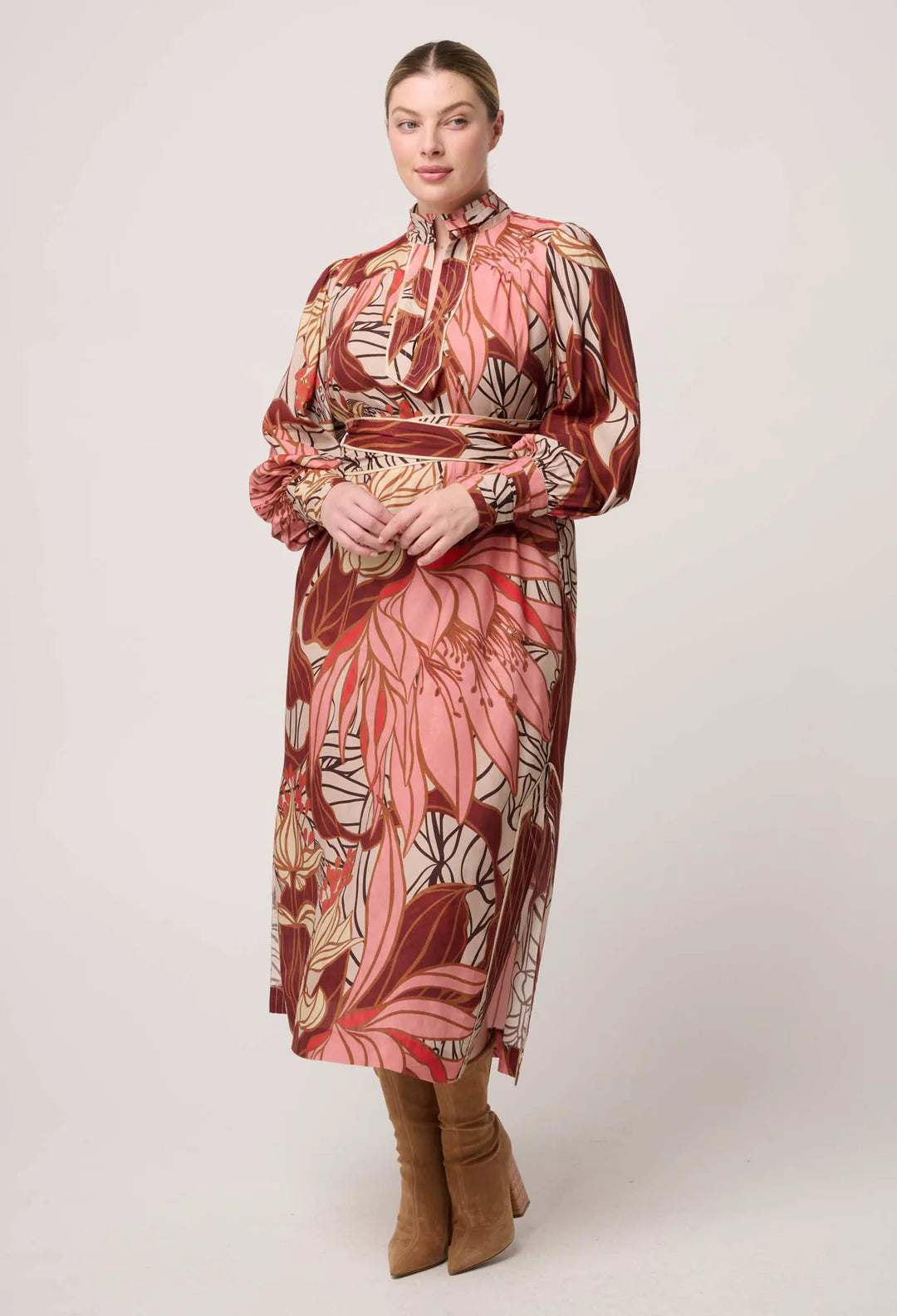 Woman wearing a patterned dress with long sleeves on a white background