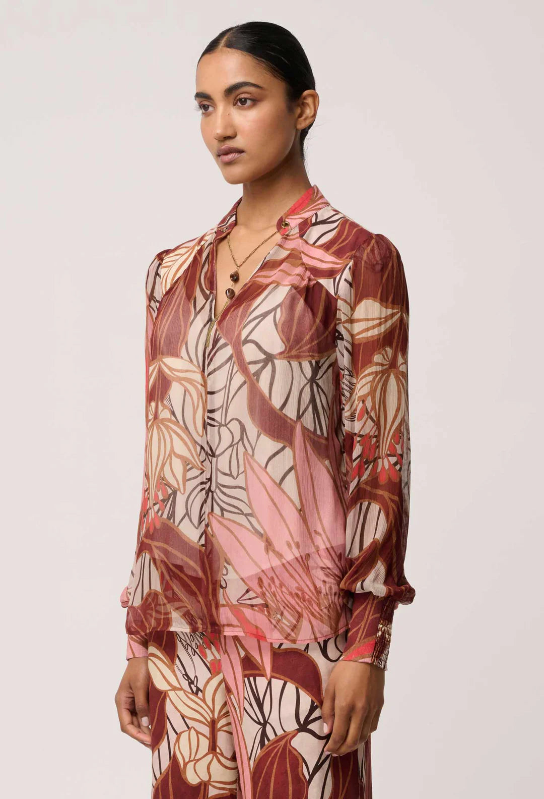 Woman wearing a patterned outfit on a plain background