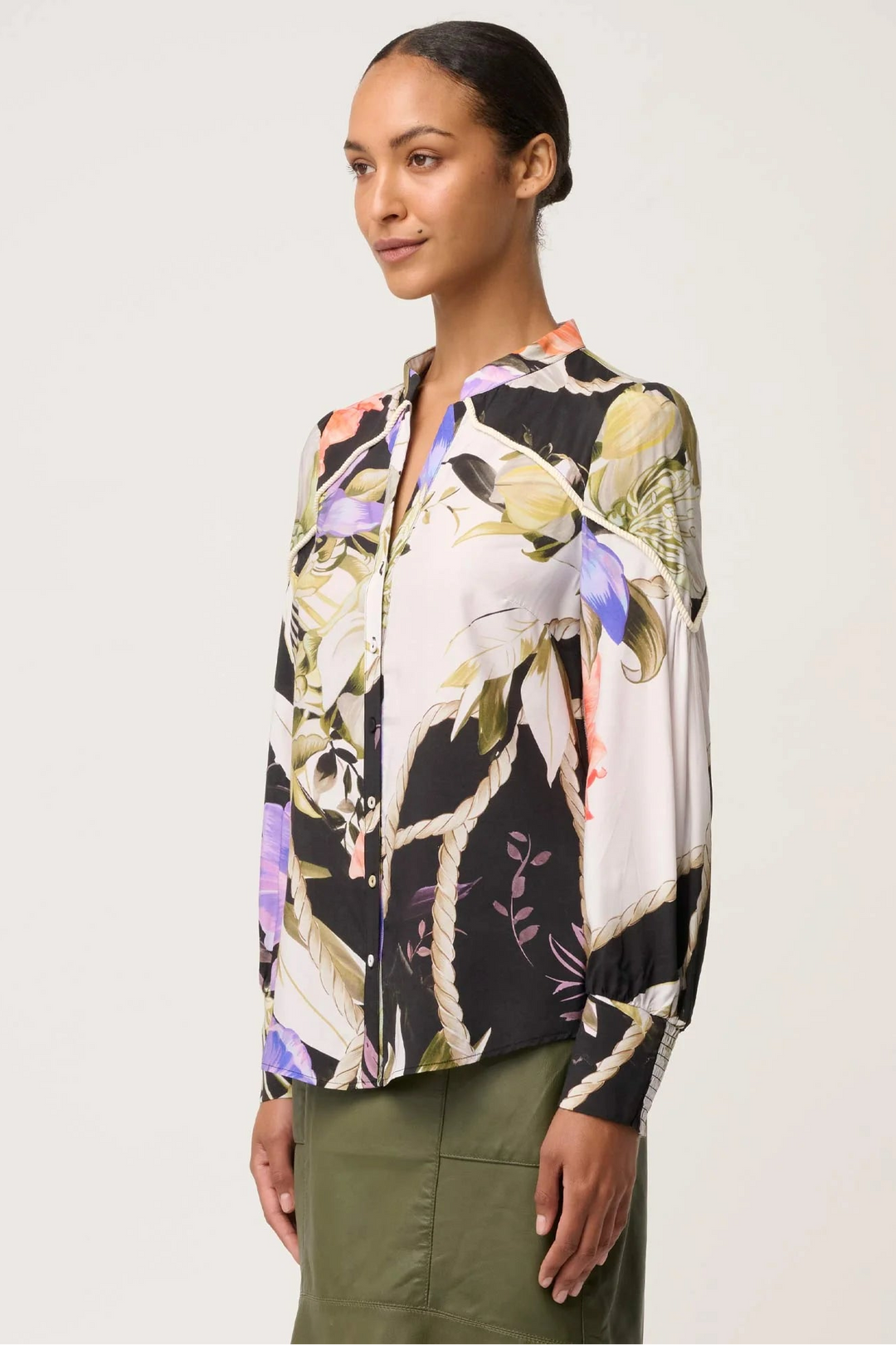 Woman wearing a floral blouse with a neutral background