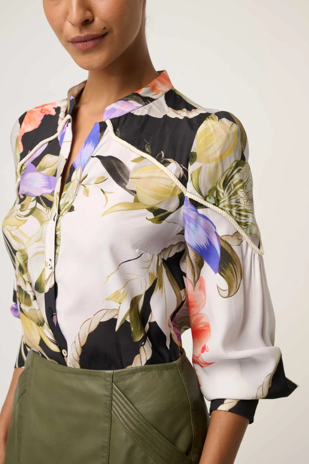 Woman wearing a floral blouse with a neutral background
