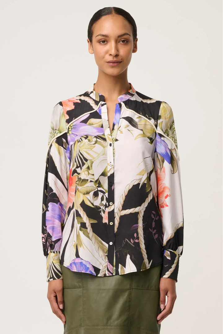 Woman wearing a floral blouse with a neutral background