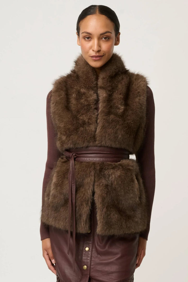 Woman wearing a brown fur vest on a white background