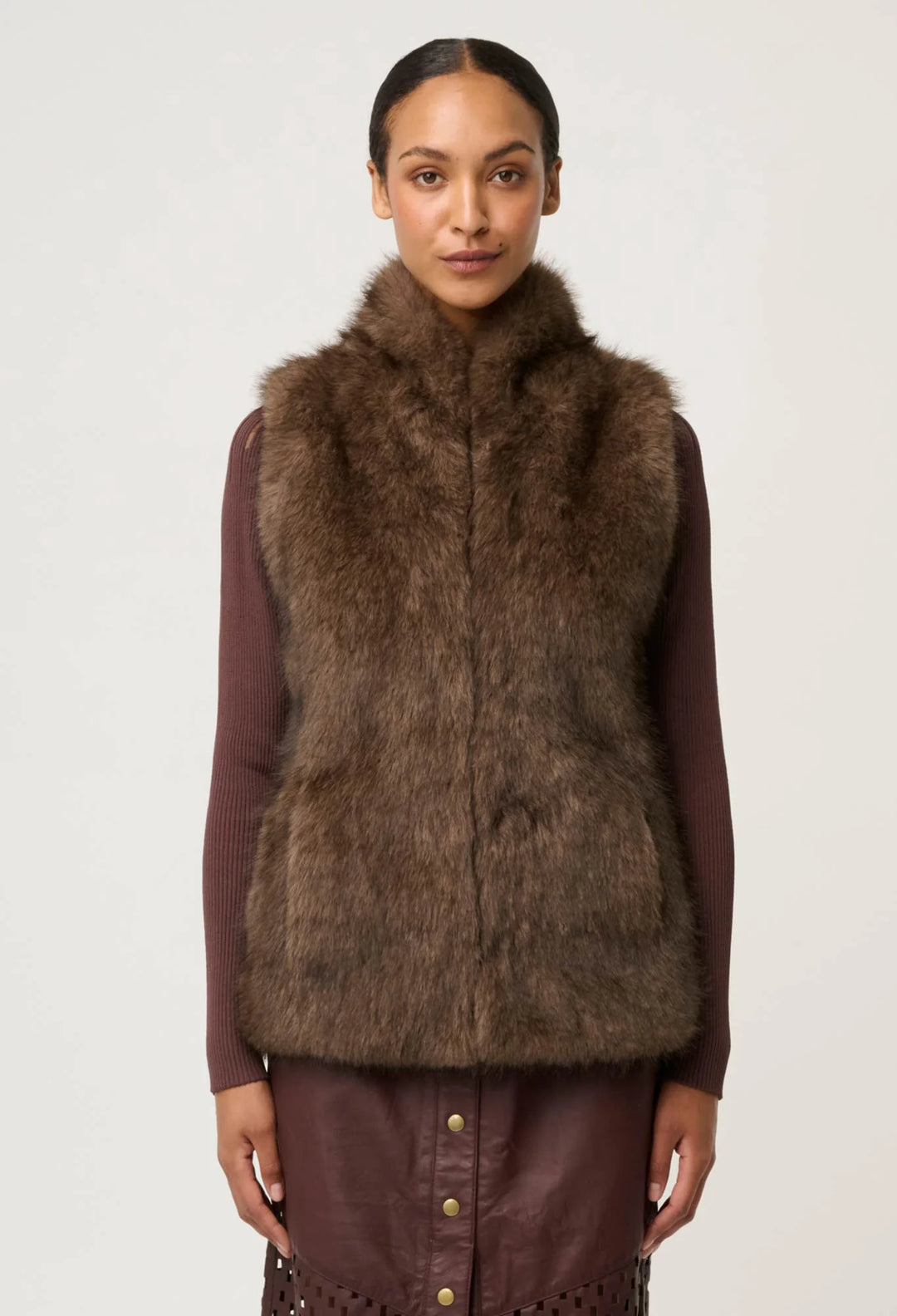 Woman wearing a brown fur vest on a white background