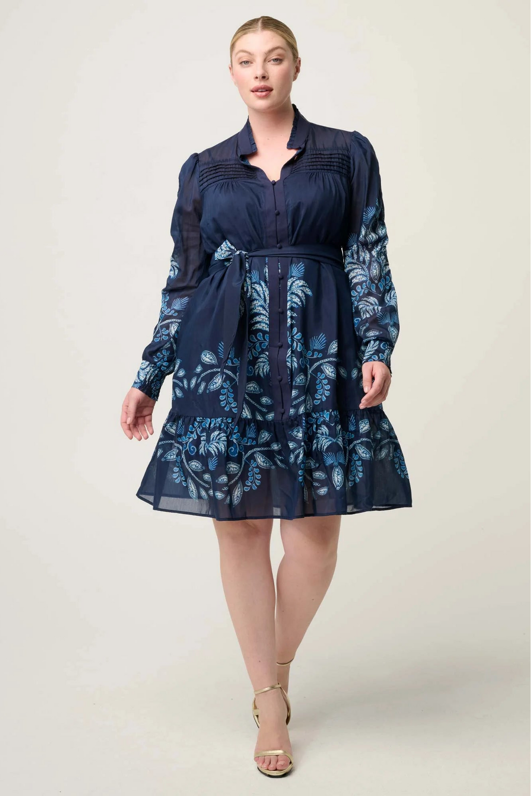 Woman wearing a navy blue floral dress on a white background