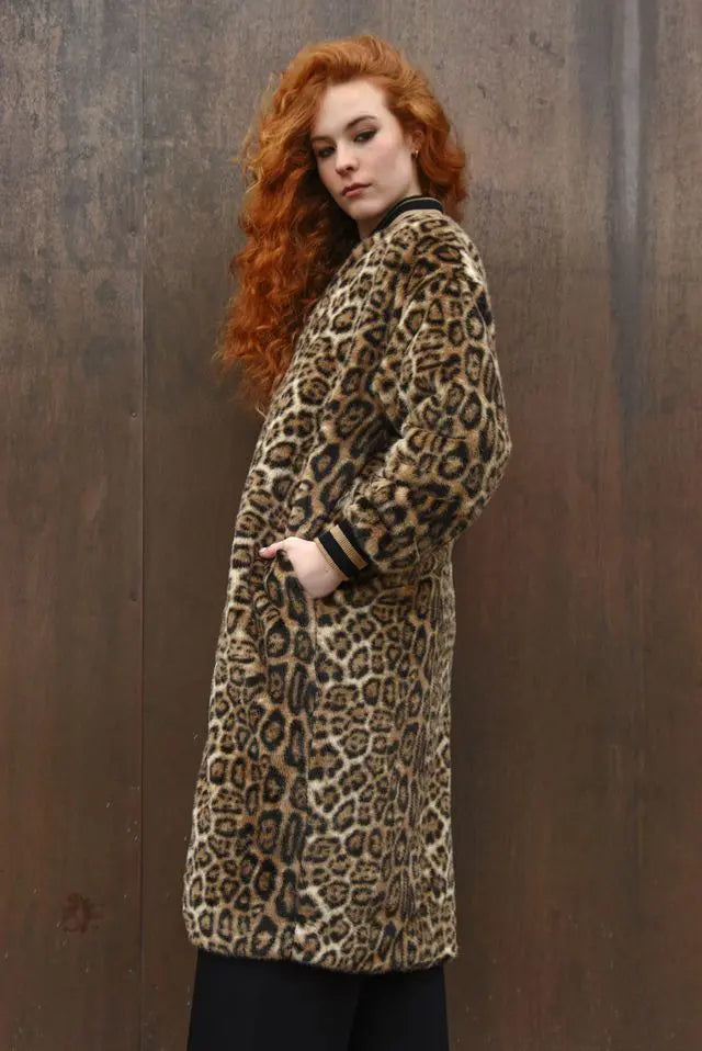 Person wearing a leopard print coat against a brown background