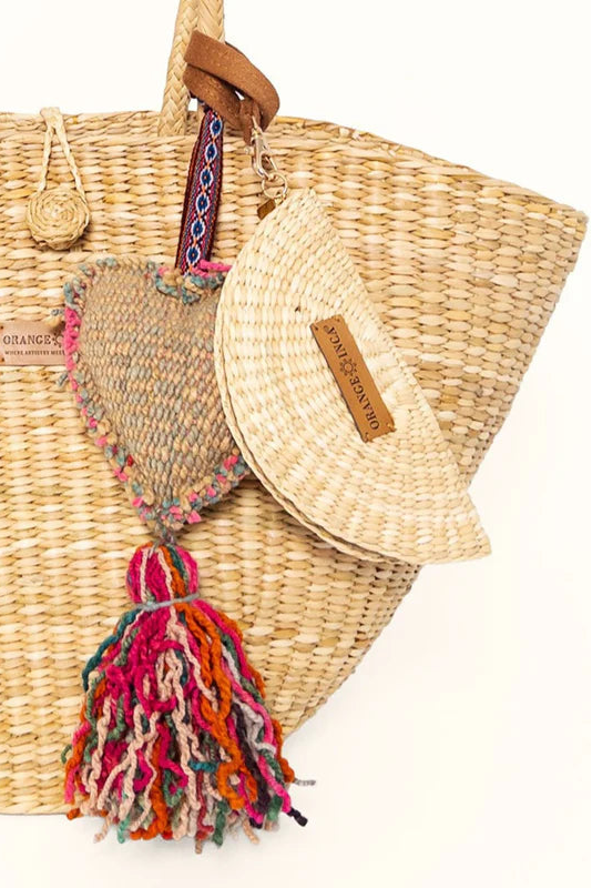Woven bag with colorful tassel and straw hat on a white background. Orange Inca Playa Tote Natural