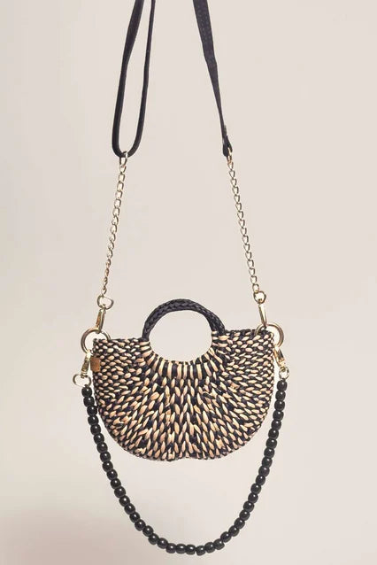 Woven handbag with black chain strap on a beige background. Orange Inca The New Mini Fiesta Bag Marbled Black