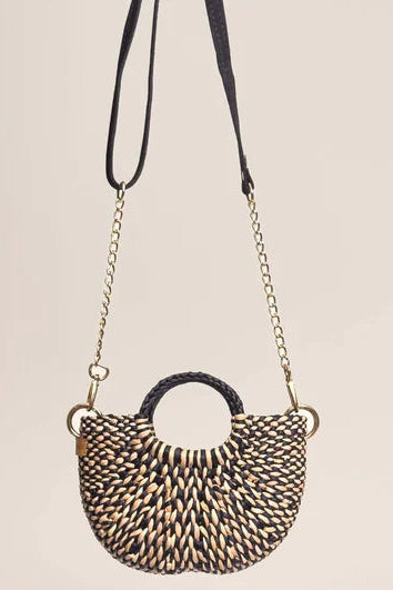 Woven handbag with a chain strap on a beige background. Orange Inca The New Mini Fiesta Bag Marbled Black