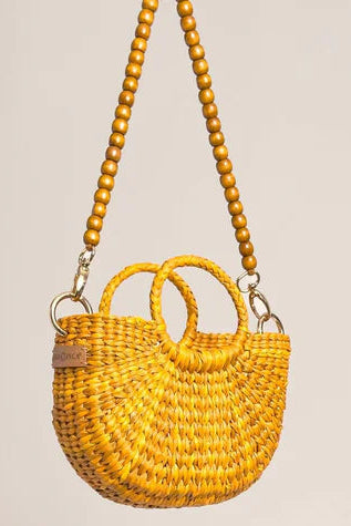 Yellow woven handbag with wooden beads on a beige background. Orange Inca The New Mini Fiesta Bag Yellow