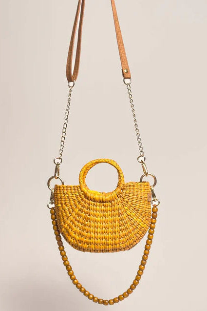 Yellow woven handbag with a chain strap on a beige background. Orange Inca The New Mini Fiesta Bag Yellow