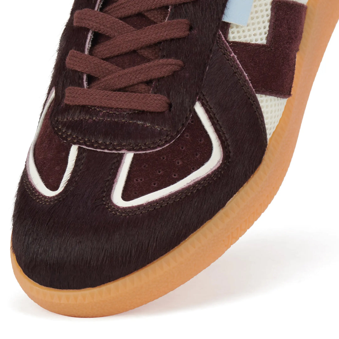 Close-up of a brown sneaker with a white sole on a white background