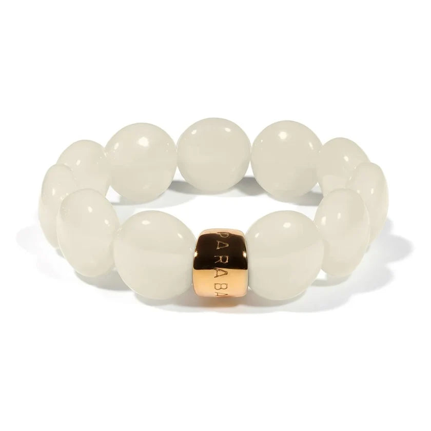 A beaded stretch bracelet featuring smooth, oval-shaped off-white beads and a central square metallic charm engraved with 'SARAB' in gold.
