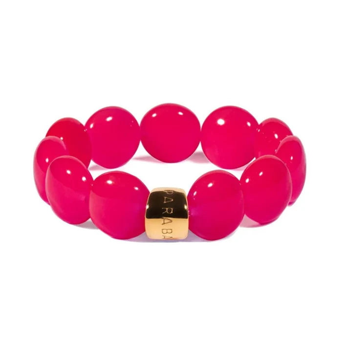 Pink beaded bracelet with a gold tag on a white background