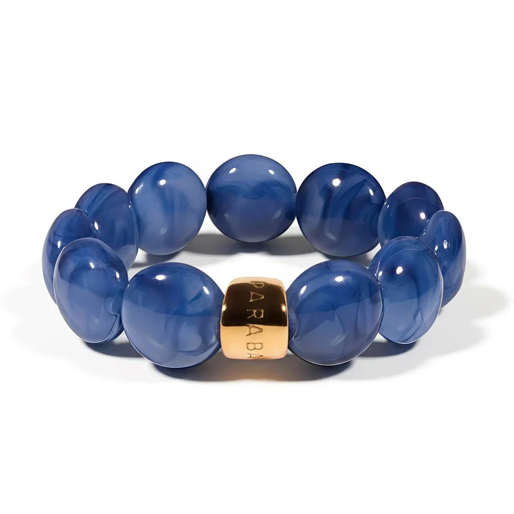 Blue beaded bracelet with a gold accent on a white background