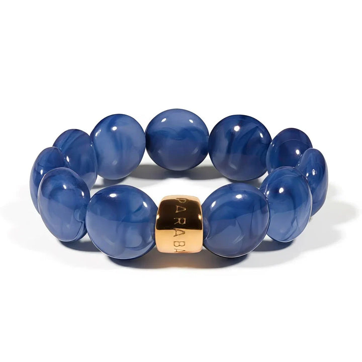 Blue beaded bracelet with a gold accent on a white background