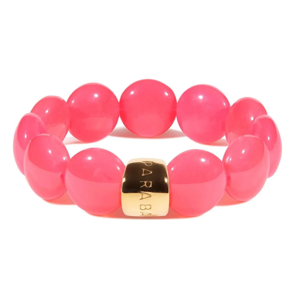 Pink beaded bracelet with a gold accent on a white background
