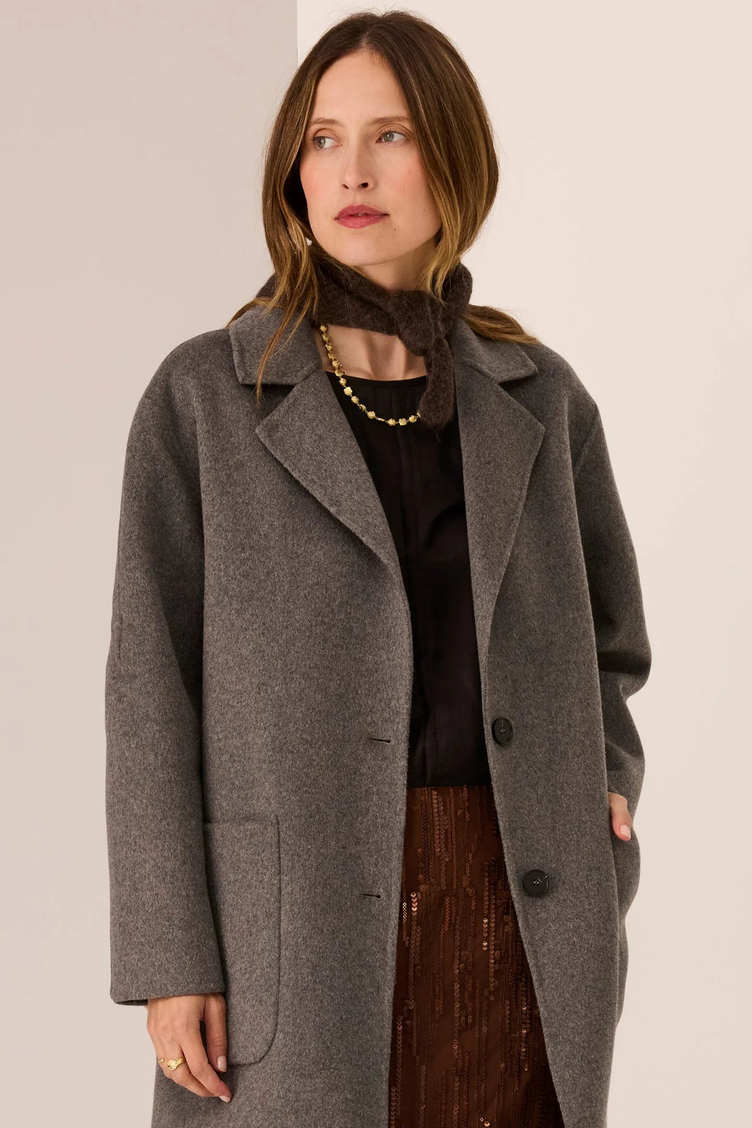 Woman wearing a gray coat with a plain background