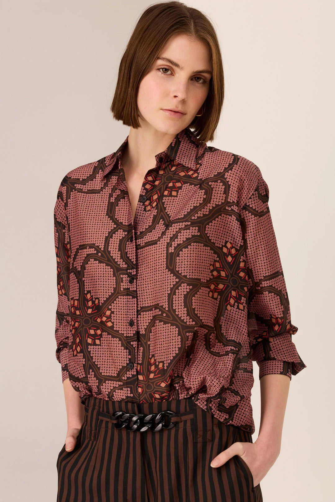 Woman wearing a patterned blouse with a plain background