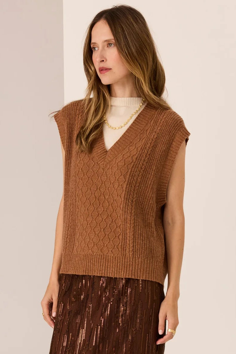 Woman wearing a brown knitted vest and skirt on a beige background