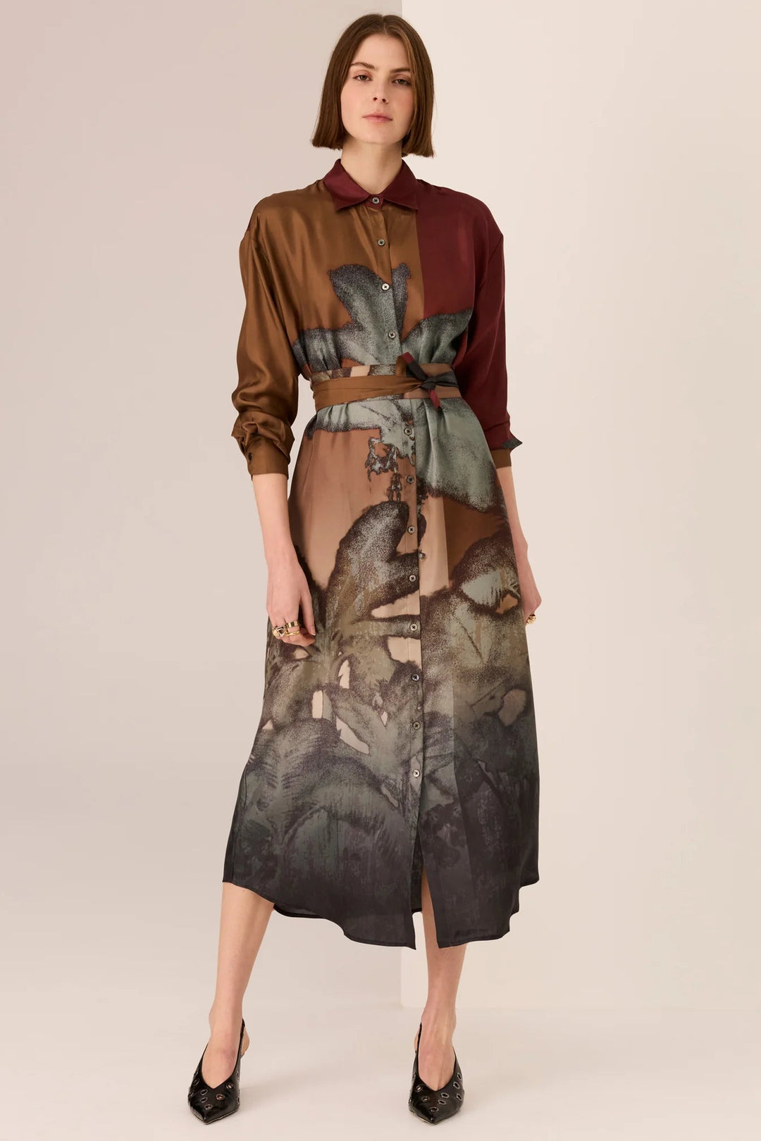 Woman wearing a brown and black patterned outfit on a beige background