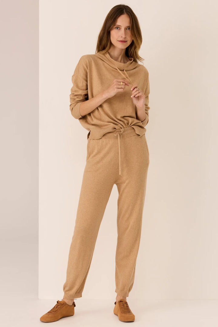 Woman wearing a beige outfit on a plain background