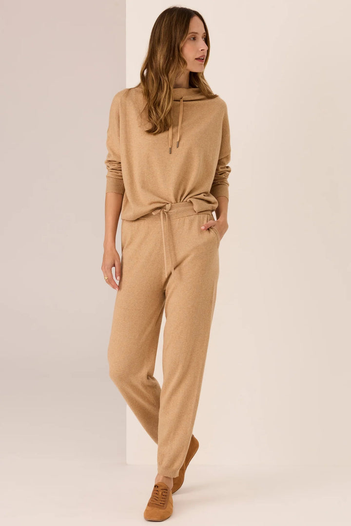 Woman wearing a beige jumpsuit on a plain background