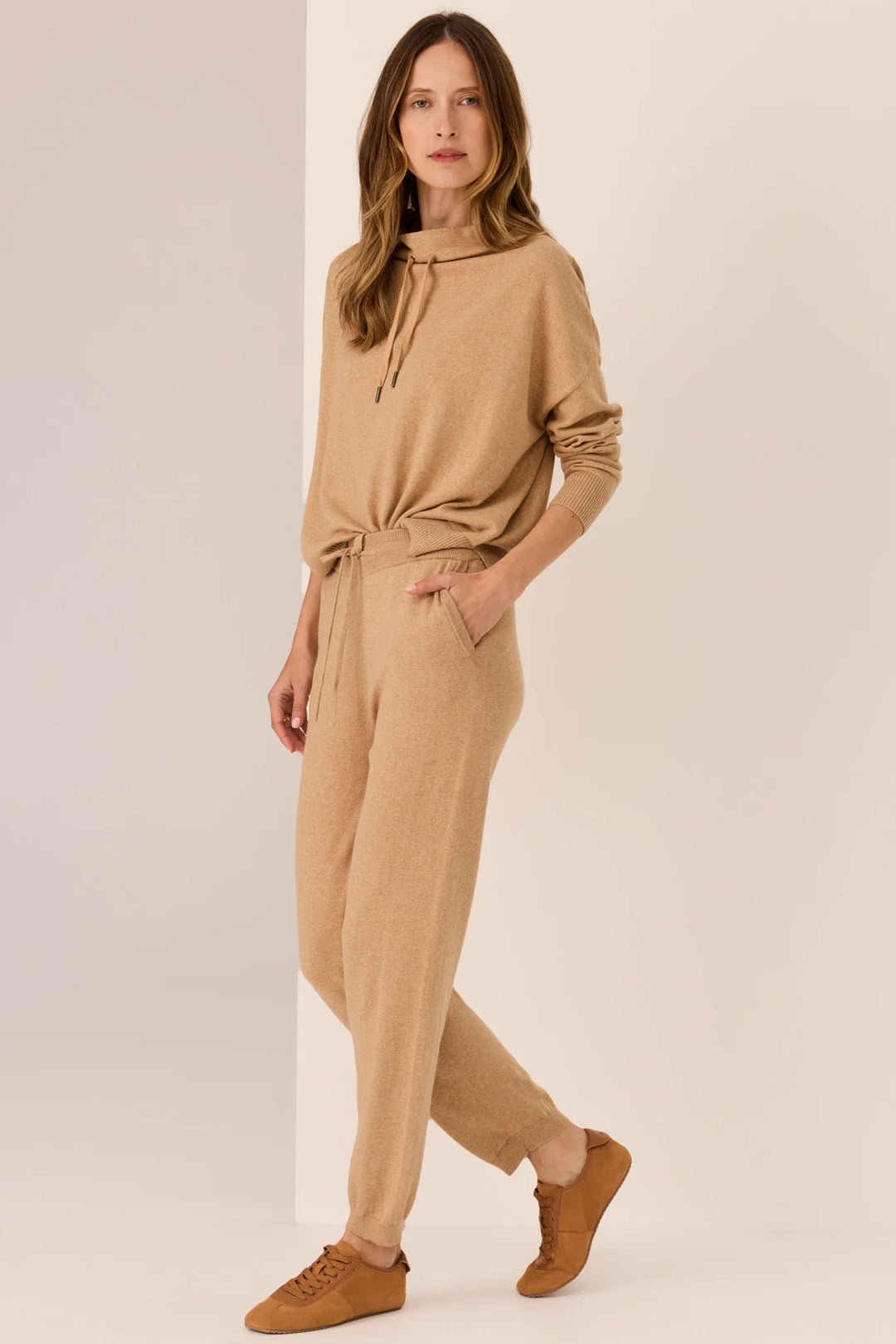 Woman wearing a beige outfit on a plain background