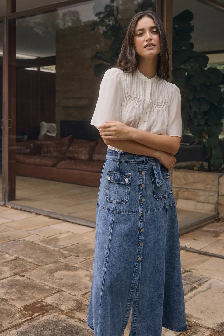 Woman standing in front of a modern building with large glass windows