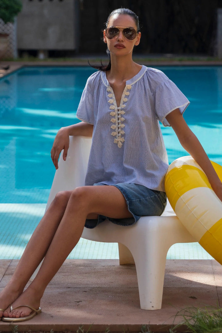 Woman sitting by a pool with a yellow and white inflatable ring