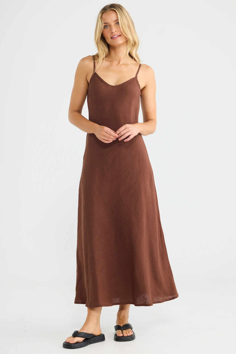 Woman wearing a brown slip dress on a white background