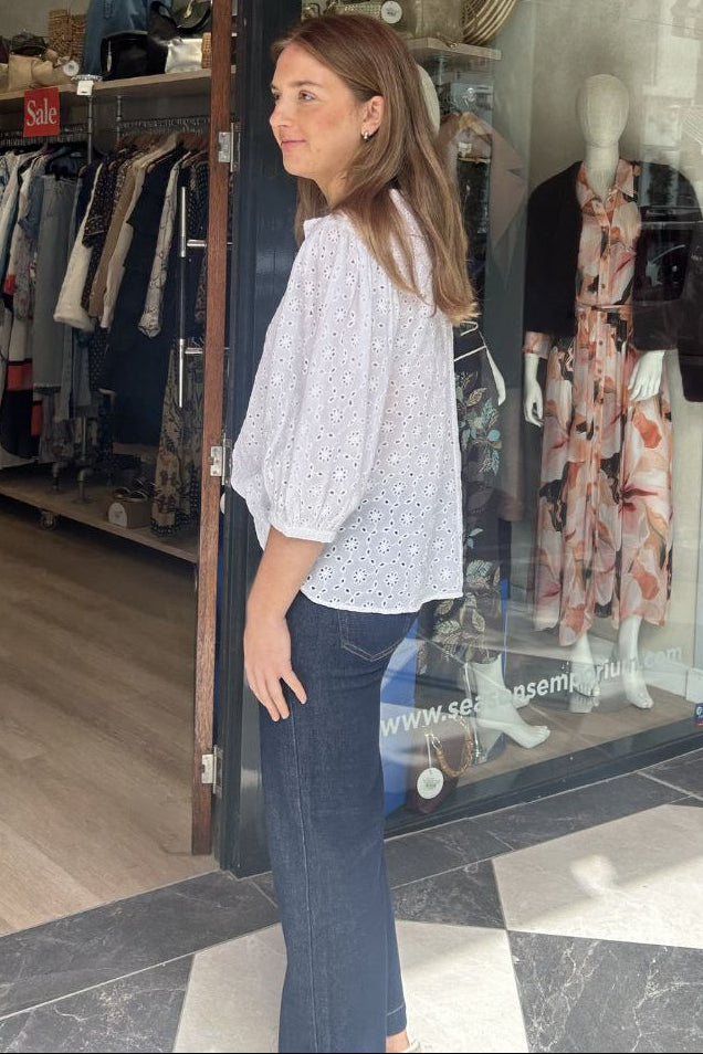 Woman standing outside a clothing store with mannequins inside