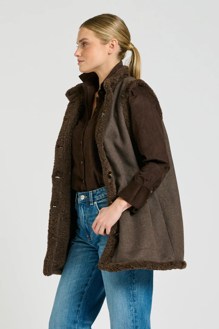 Woman wearing a brown coat with a white background