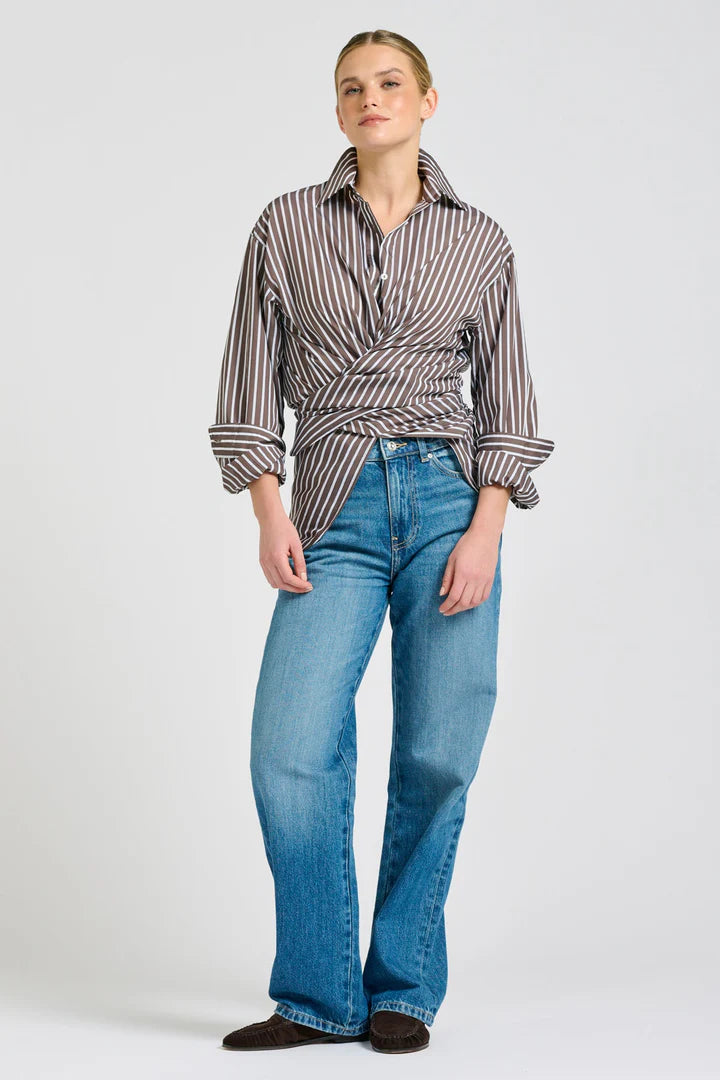 Woman wearing a striped shirt and blue jeans on a white background