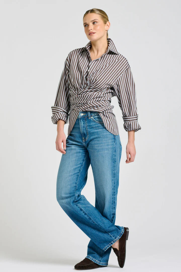Woman wearing a striped shirt and blue jeans on a white background