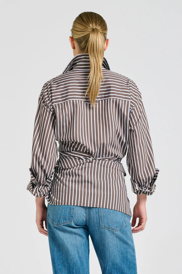 Person wearing a striped shirt and blue jeans on a white background