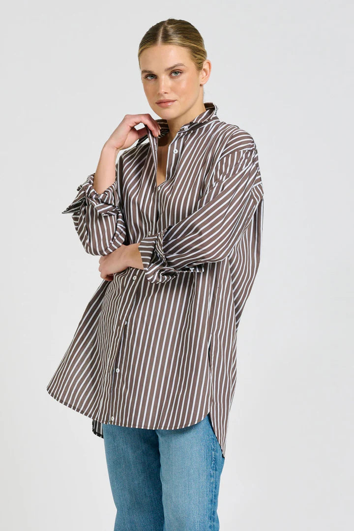 Woman wearing a striped shirt and jeans on a white background