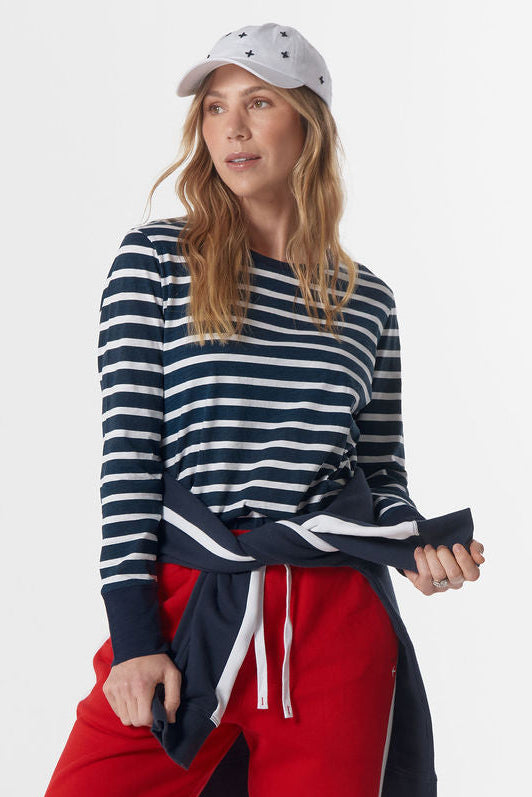 Person wearing a striped sweater, red pants, and a cap on a white background