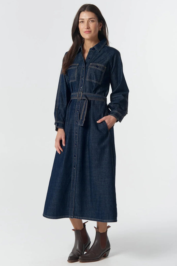Woman wearing a long denim dress on a white background