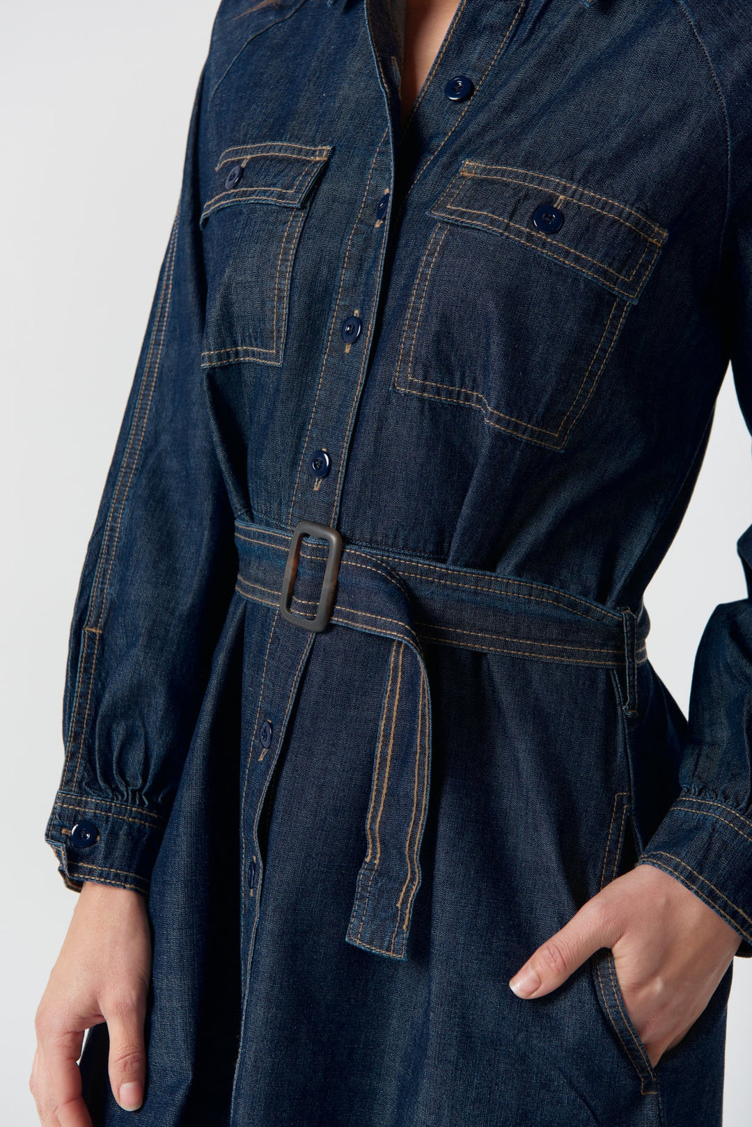 Denim dress with pockets and a belt on a white background