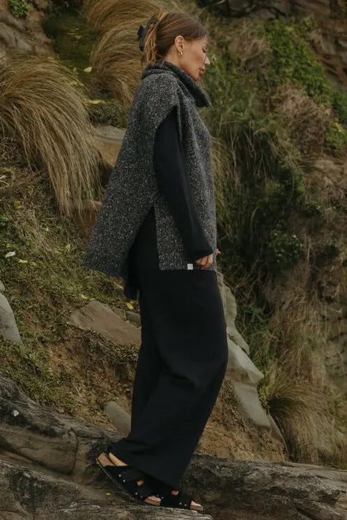Person standing on a rocky outcrop with a natural, rocky landscape in the background