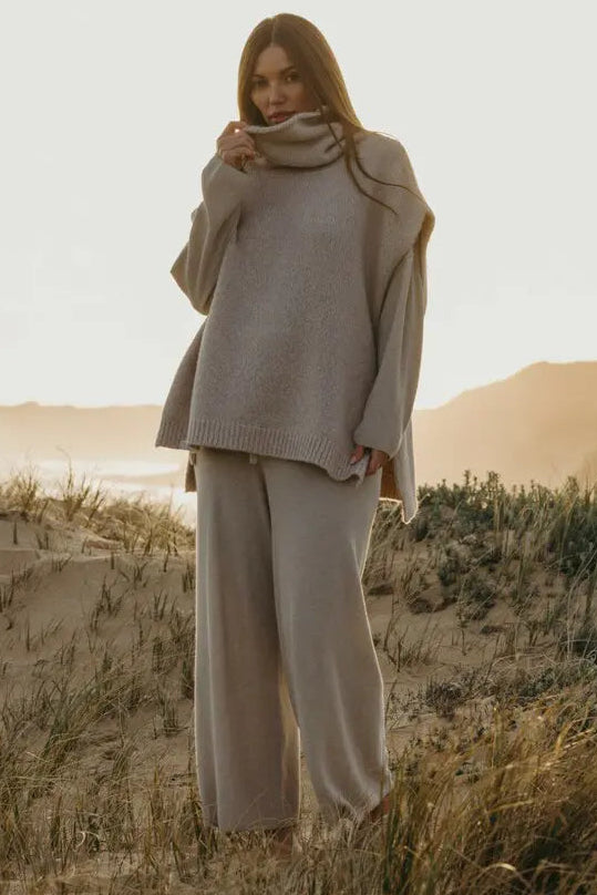 Woman in a beige outfit standing in a desert landscape