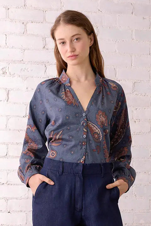 Woman wearing a denim outfit with a white brick wall background