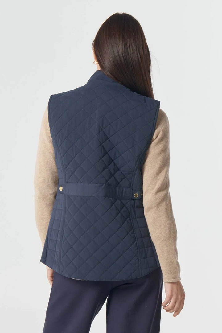 Person wearing a navy quilted vest and pants on a white background