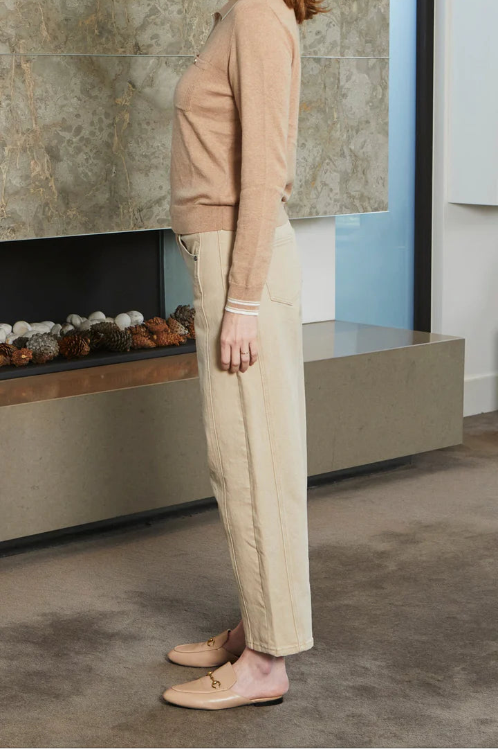 Woman standing in a modern room with stone wall and fireplace.